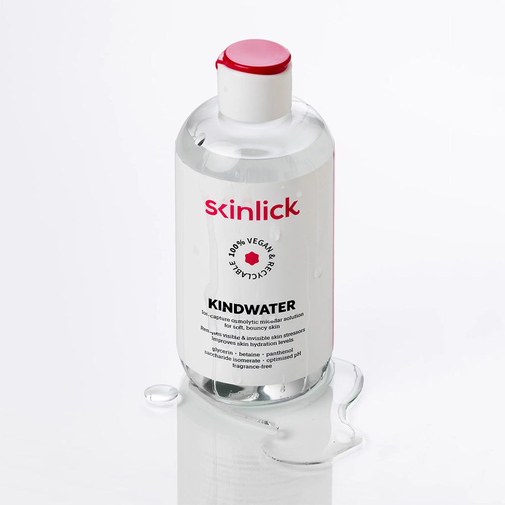 Flacone di SKINLICK Kindwater acqua micellare con liquido versato. Liquido trasparente.