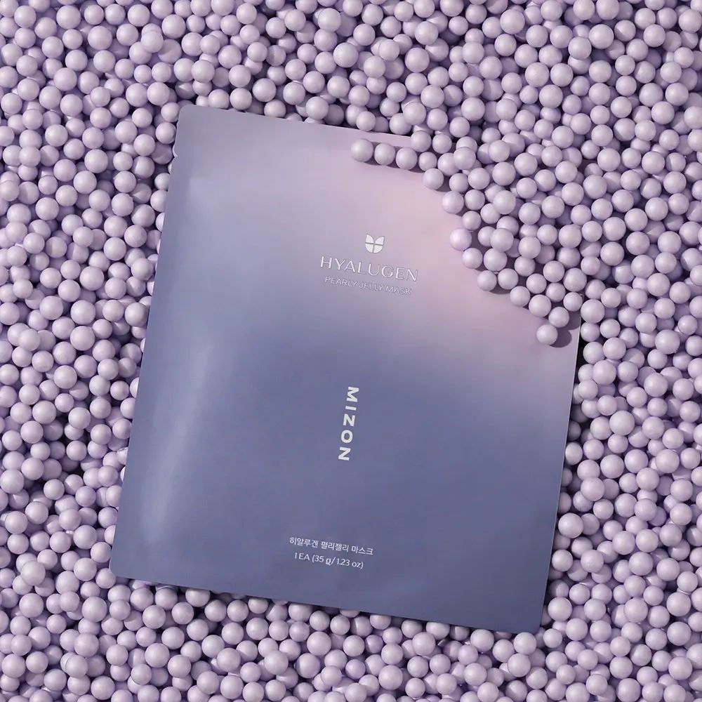 Confezione MIZON Hyalugen Pearly Jelly Mask. Sfumatura viola, scritta MIZON e Hyalugen. Posizionata su perle viola.