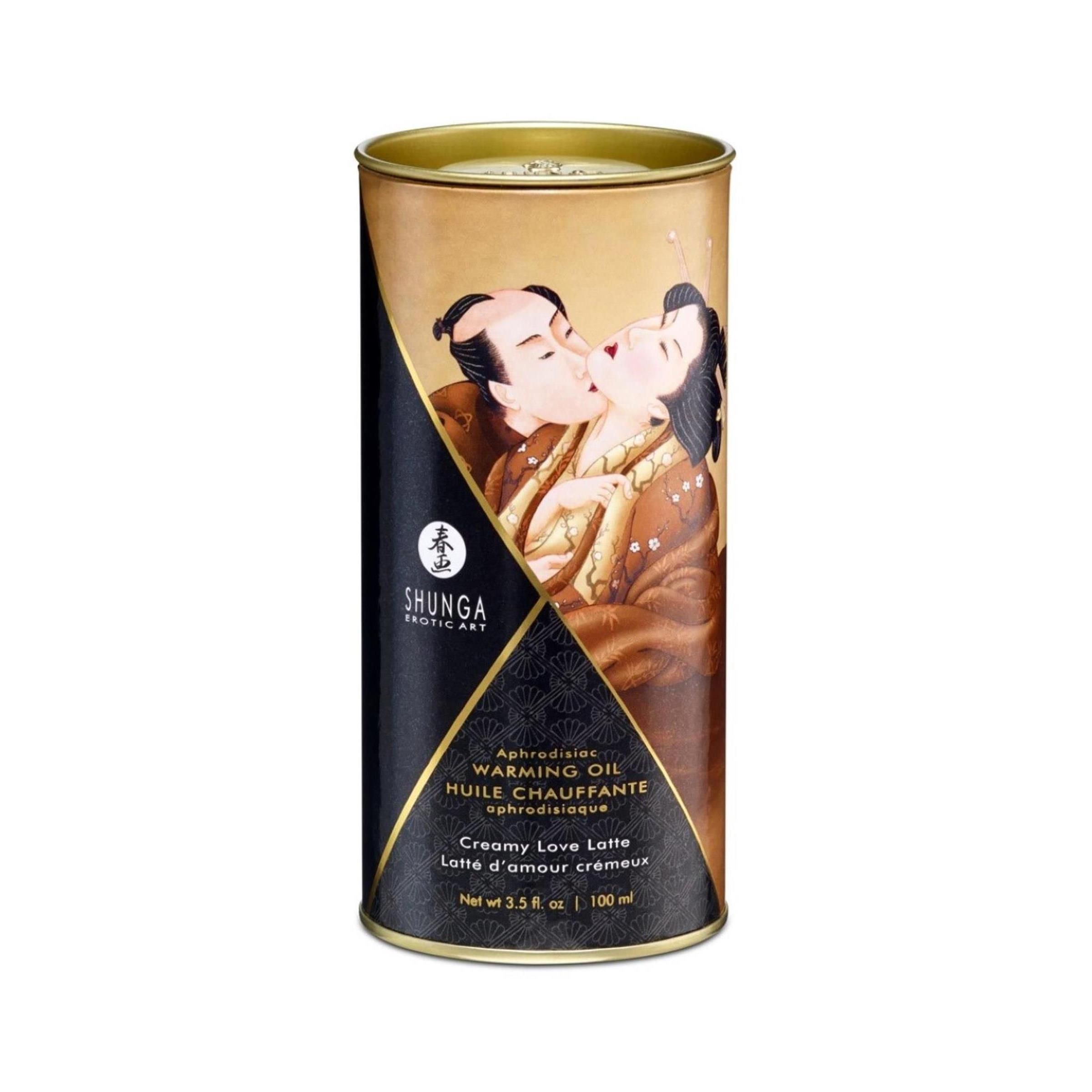 Scatola cilindrica di olio per massaggio. Stampa di coppia che si bacia. Testo: Shunga, Warming Oil, Creamy Love Latte, 100 ml.