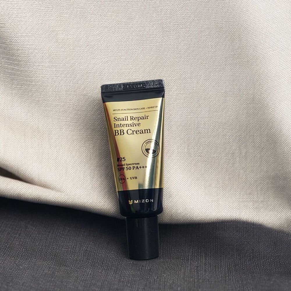 Crema colorata in tubo. Tubo dorato con tappo nero. Scritta: Snail Repair Intensive BB Cream, Nr. 25, SPF 50 PA+++. Marchio: MIZON.