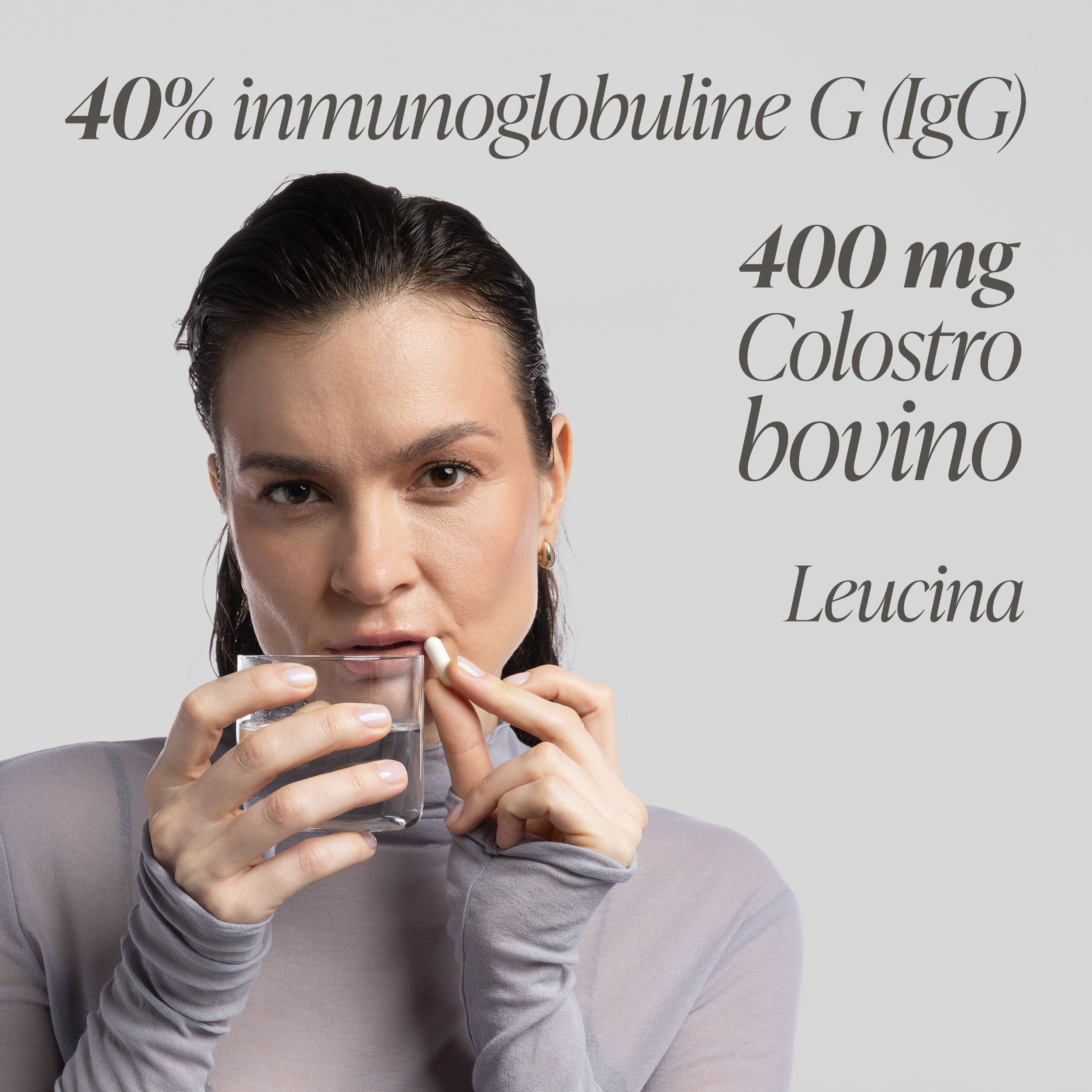 Donna assume una capsula di colostro Primabiotic con acqua. "400 mg Colostro bovino".