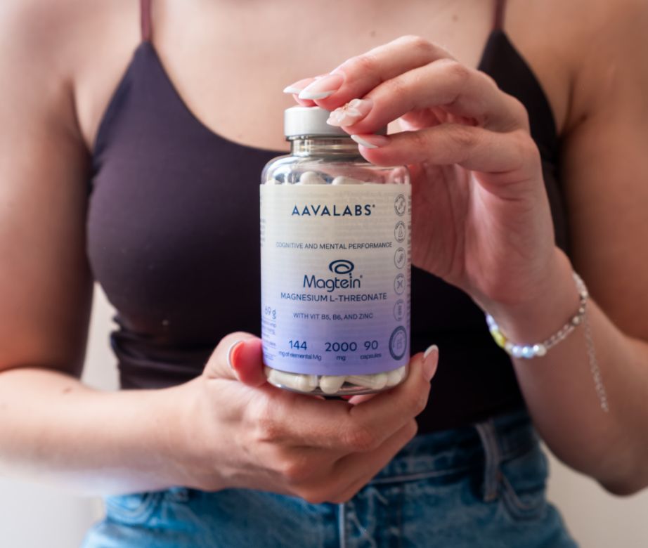 Persona che tiene un flacone di capsule Aavalabs Magtein Magnesio L-Treonato.