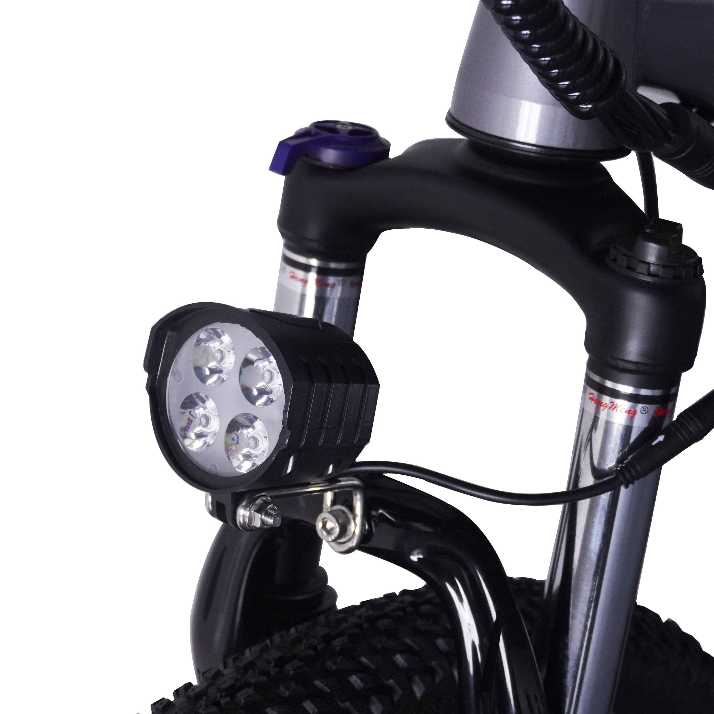 Primo piano della forcella anteriore di una bici elettrica. Faro con quattro LED. Forcella e supporto neri.