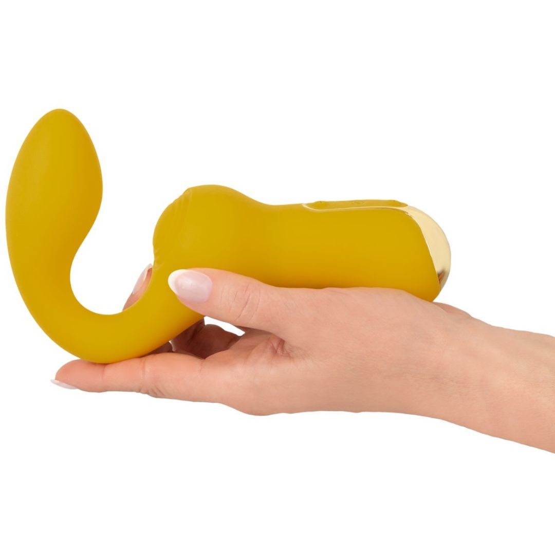 Vibratore giallo dalla forma curva, tenuto in mano.