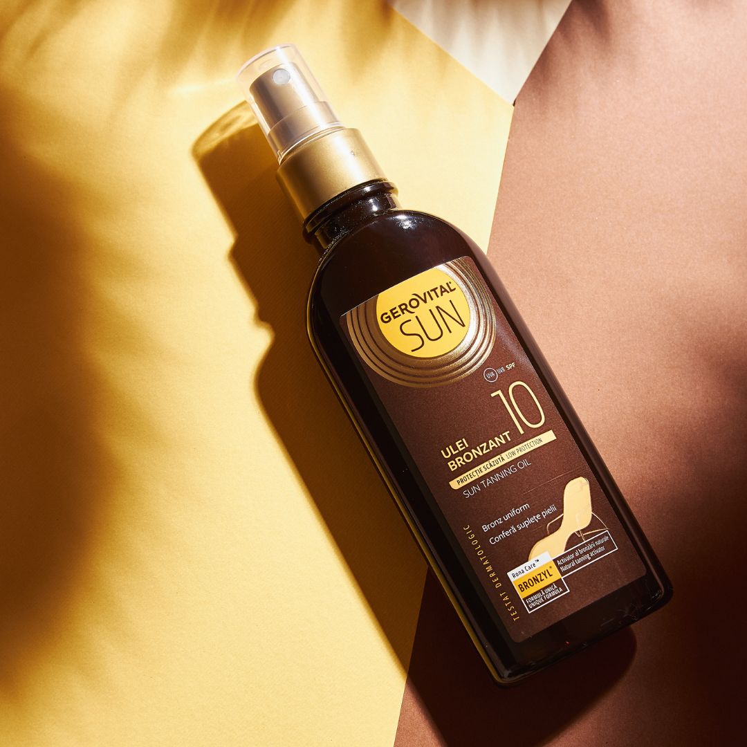 Olio abbronzante Gerovital Sun SPF 10, flacone marrone con vaporizzatore. Scritta: Ulei Bronzant, Sun Tanning Oil. Sfondo: giallo e marrone.