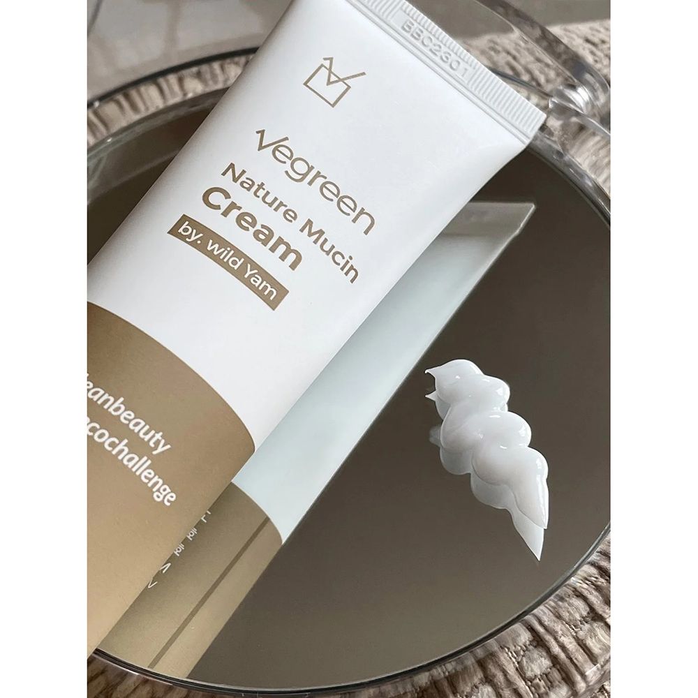 Tubo bianco con scritta Vegreen Nature Mucin Cream. Accanto, una noce di crema su uno specchio.