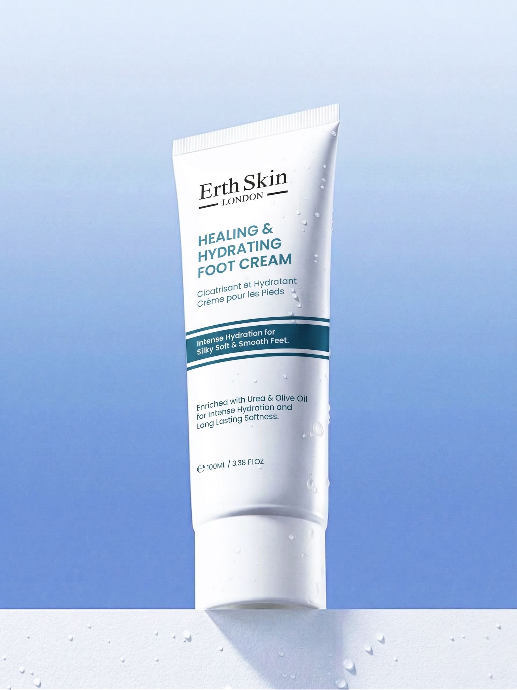 Tubo bianco Erth Skin London Crema piedi lenitiva e idratante su sfondo blu con gocce d'acqua.