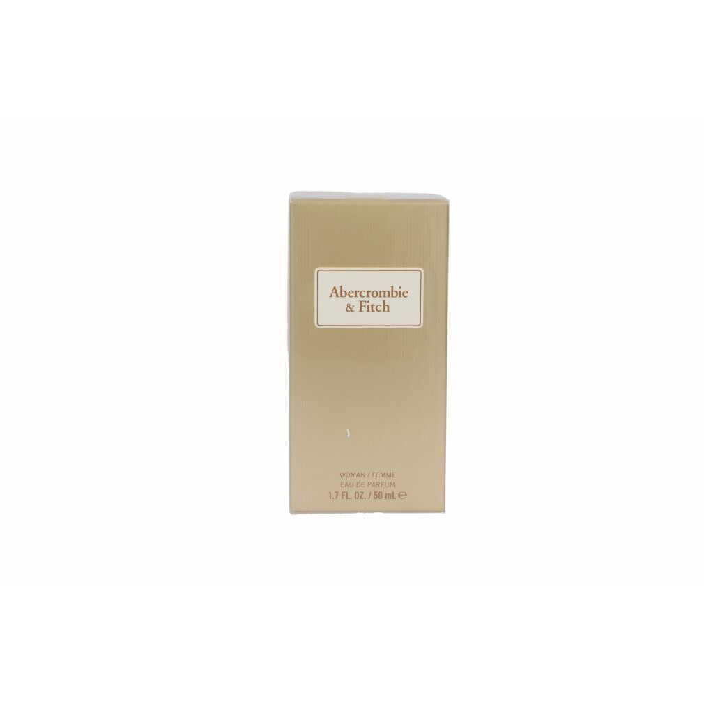Scatola dorata. Etichetta con nome del prodotto. Testo: WOMAN/FEMME, 1.7 FL. OZ. / 50 ml e.