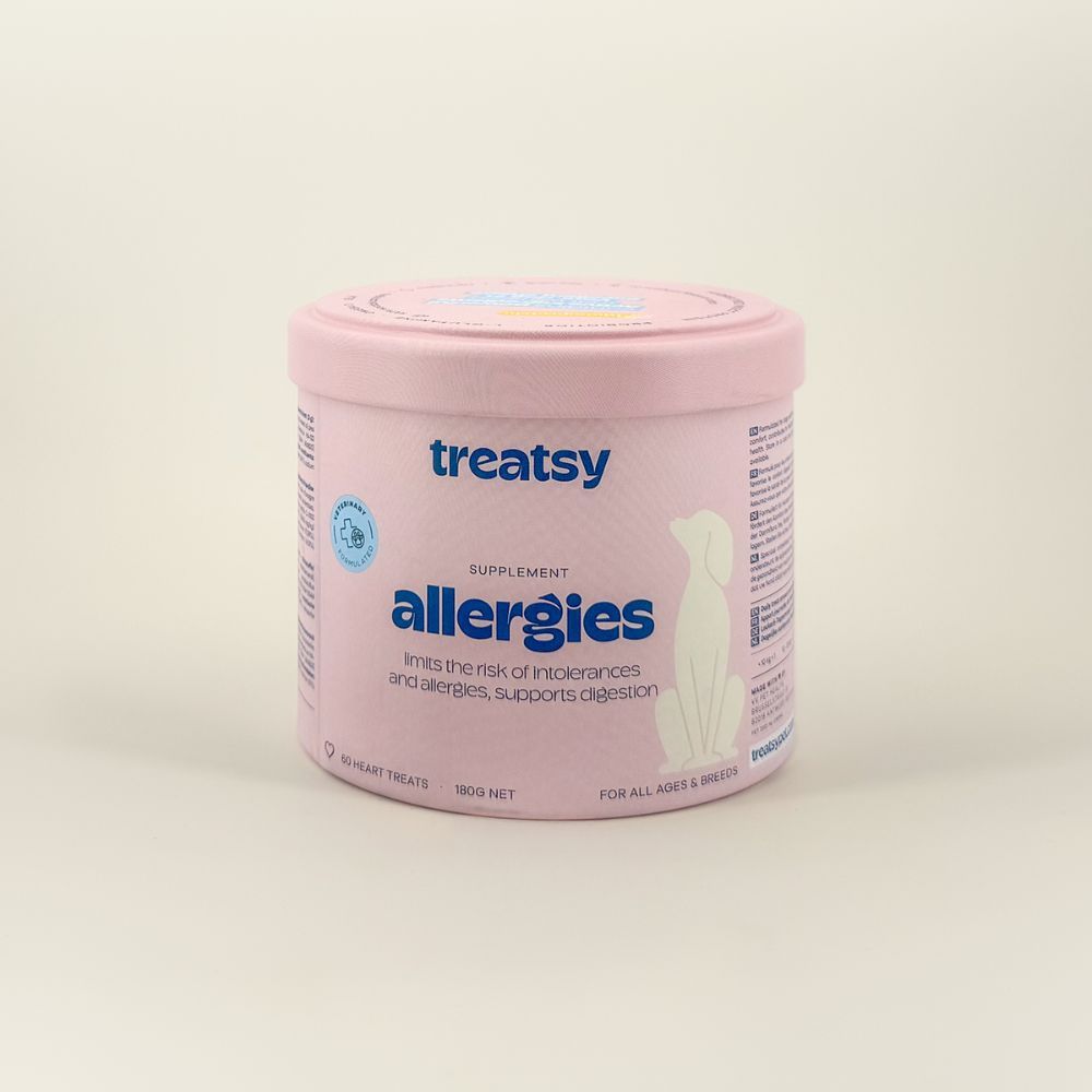 Barattolo rosa con "Treatsy Allergies" per cani. Sigillo veterinario. Testo: Allergie, supporta la digestione.