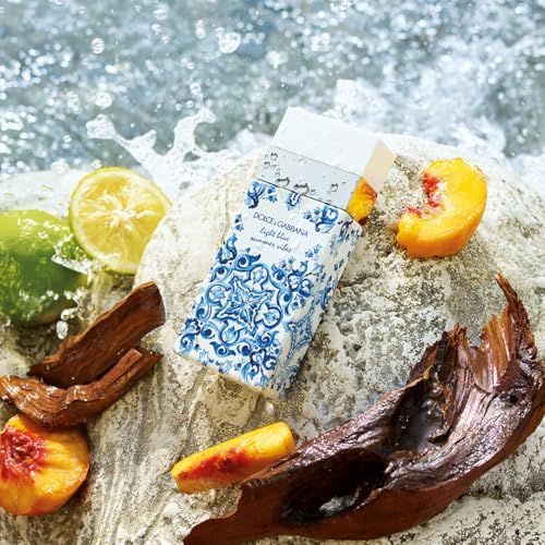 Flacone e confezione Dolce & Gabbana Light Blue Summer Vibes. Su pietra. Frutta e acqua. Motivo blu.