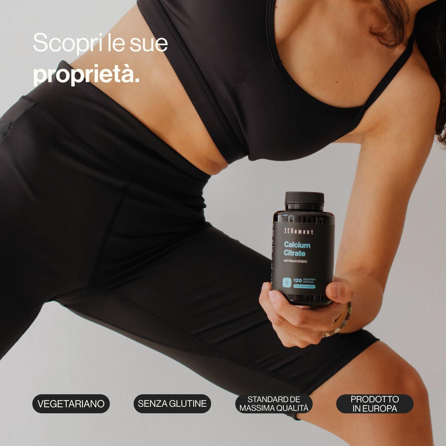 Persona tiene bottiglia nera di Zenement Calciumcitrat. Scritte: Vegetariano, Senza glutine, Standard di qualità, Prodotto in Europa.
