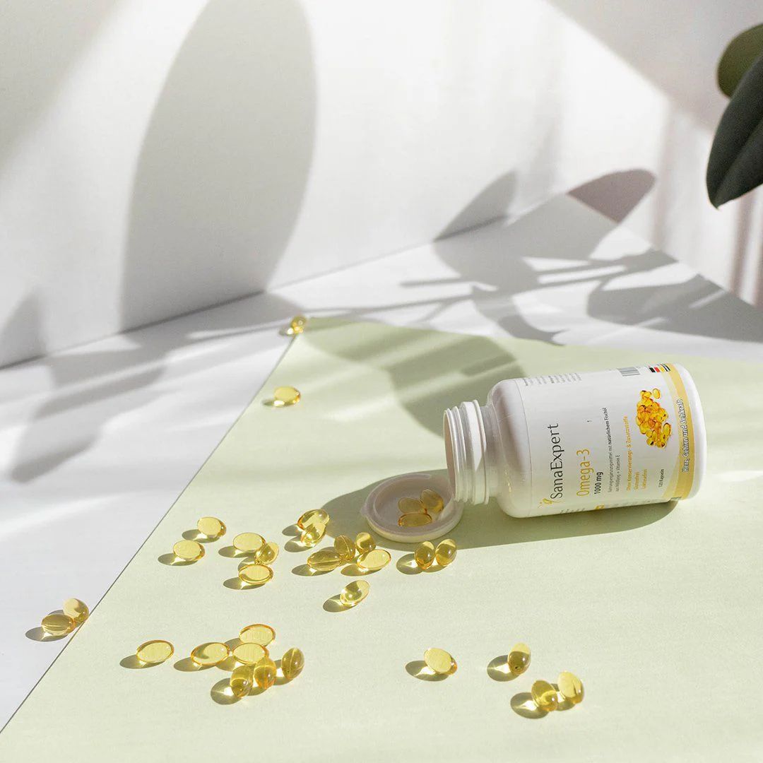 Bottiglia SanaExpert Omega-3, capsule sparse. Su sfondo giallo-verde.