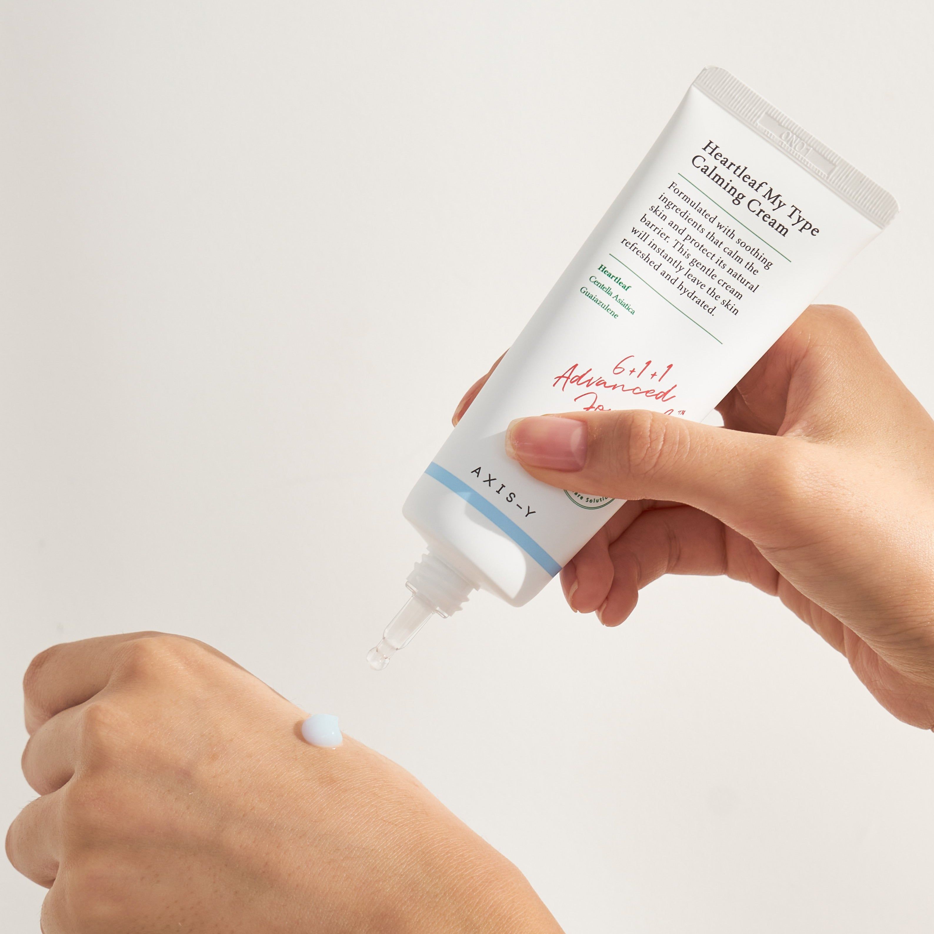 Mano che tiene tubo 'Heartleaf My Type Calming Cream'. Crema spremuta sulla mano.