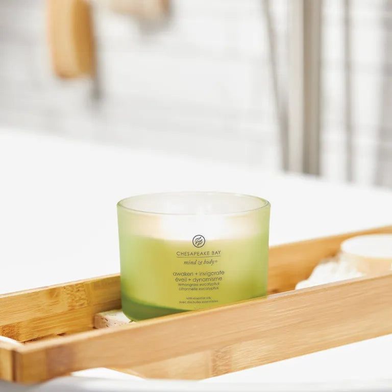 Candela verde in contenitore di vetro su vassoio di legno. Scritta: Chesapeake Bay, mind & body, awaken + invigorate.
