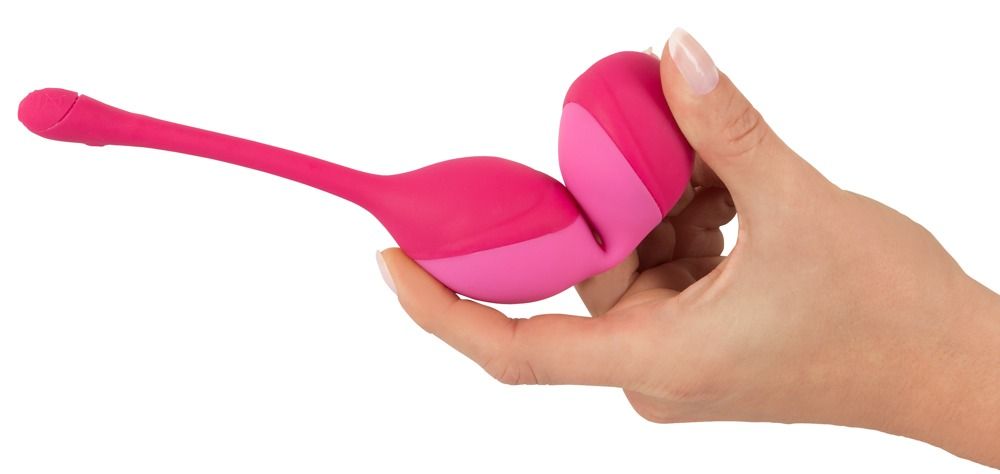 Mano che tiene sfere d'amore rosa.