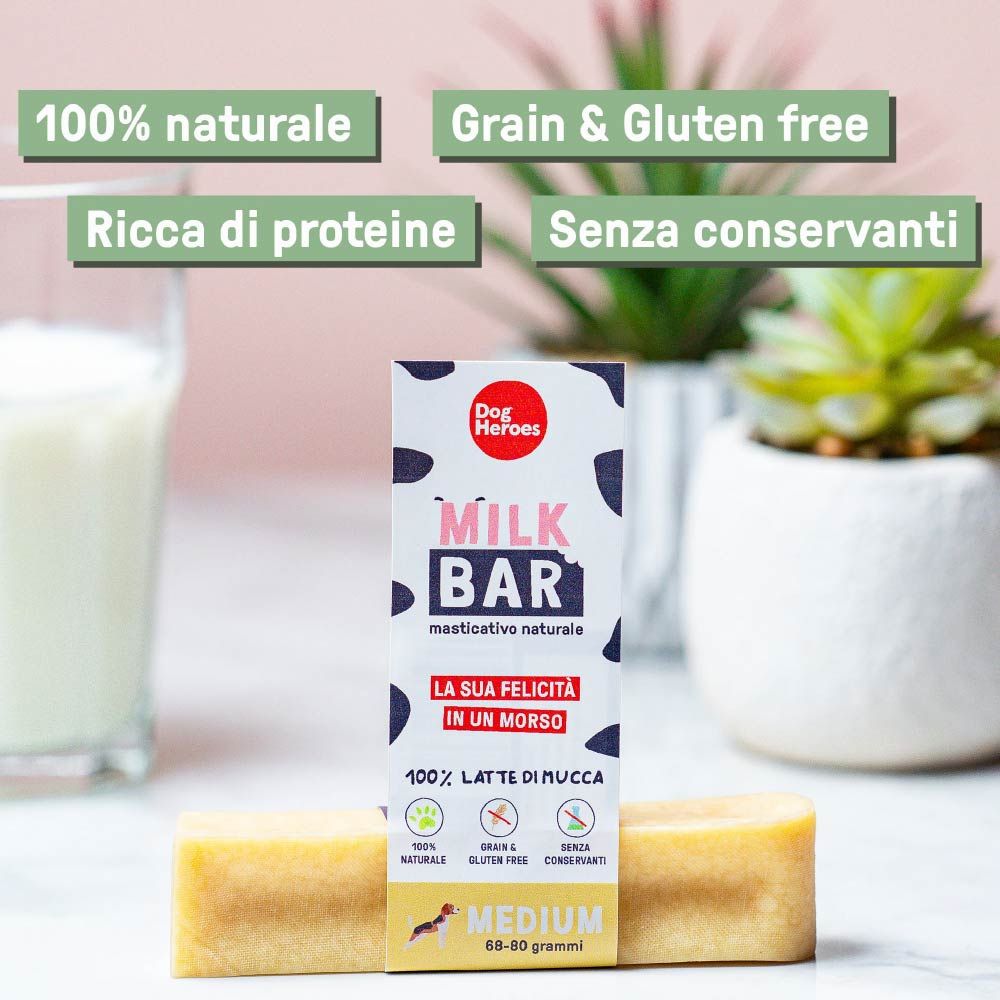 Milk Bar con confezione. La confezione mostra il nome del marchio e le informazioni sul prodotto. La barretta è marrone chiaro e rettangolare.