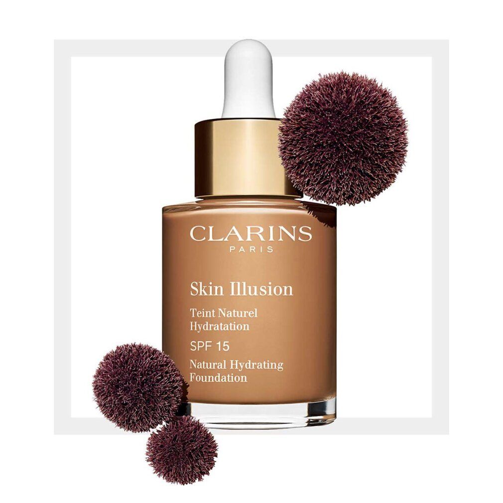 Flacone di fondotinta liquido e due pennelli. Scritte: Clarins, Skin Illusion, Teint Naturel Hydratation, SPF 15.
