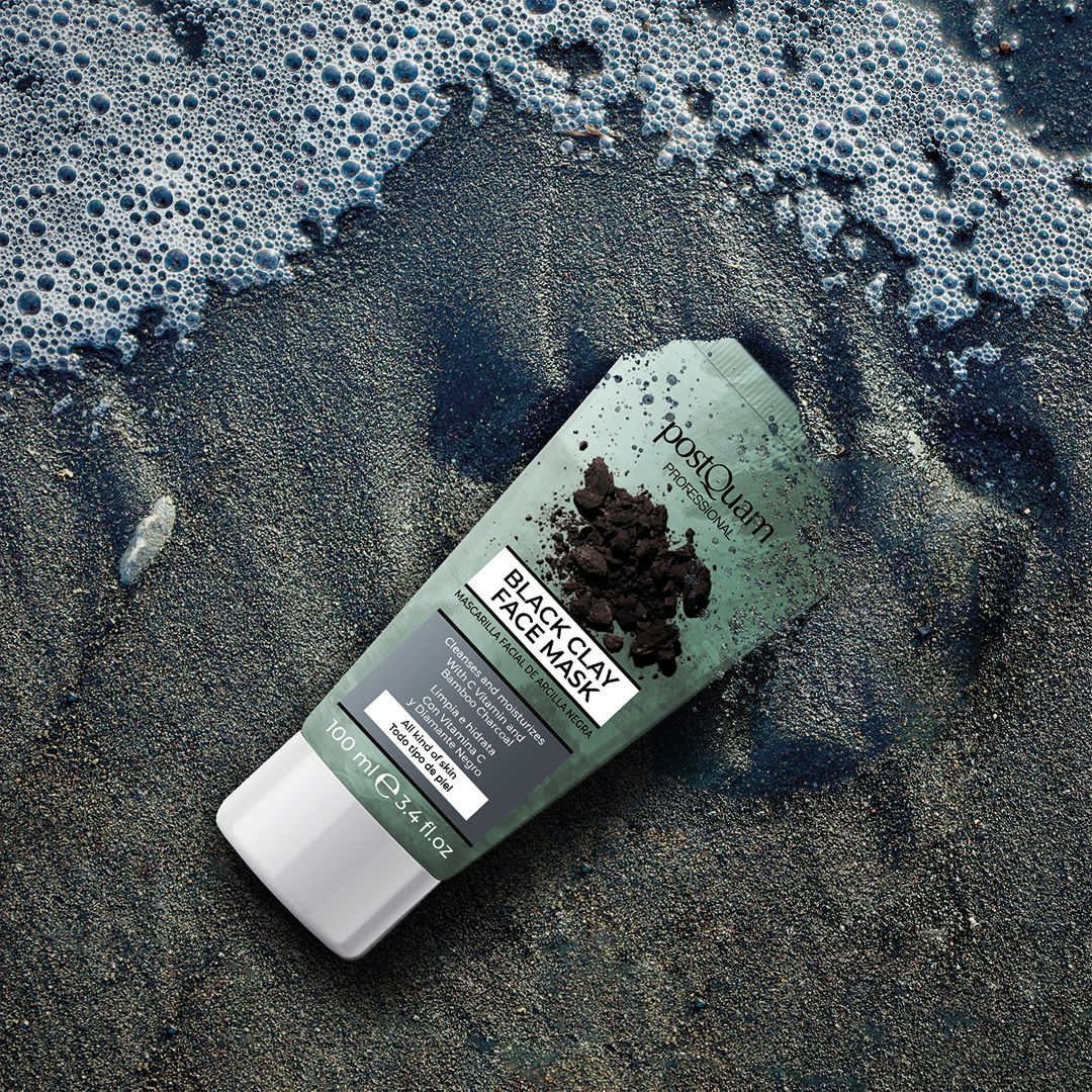 Tubo di maschera viso sulla spiaggia. Testo: Black Clay Face Mask, deterge e idrata con vitamina C e carbone di bambù. 100 ml.