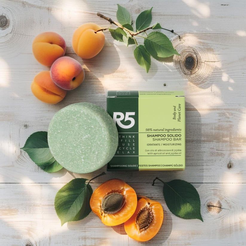 Panetto shampoo verde rotondo e scatola con testo. Albicocche e foglie su legno. Vegano.