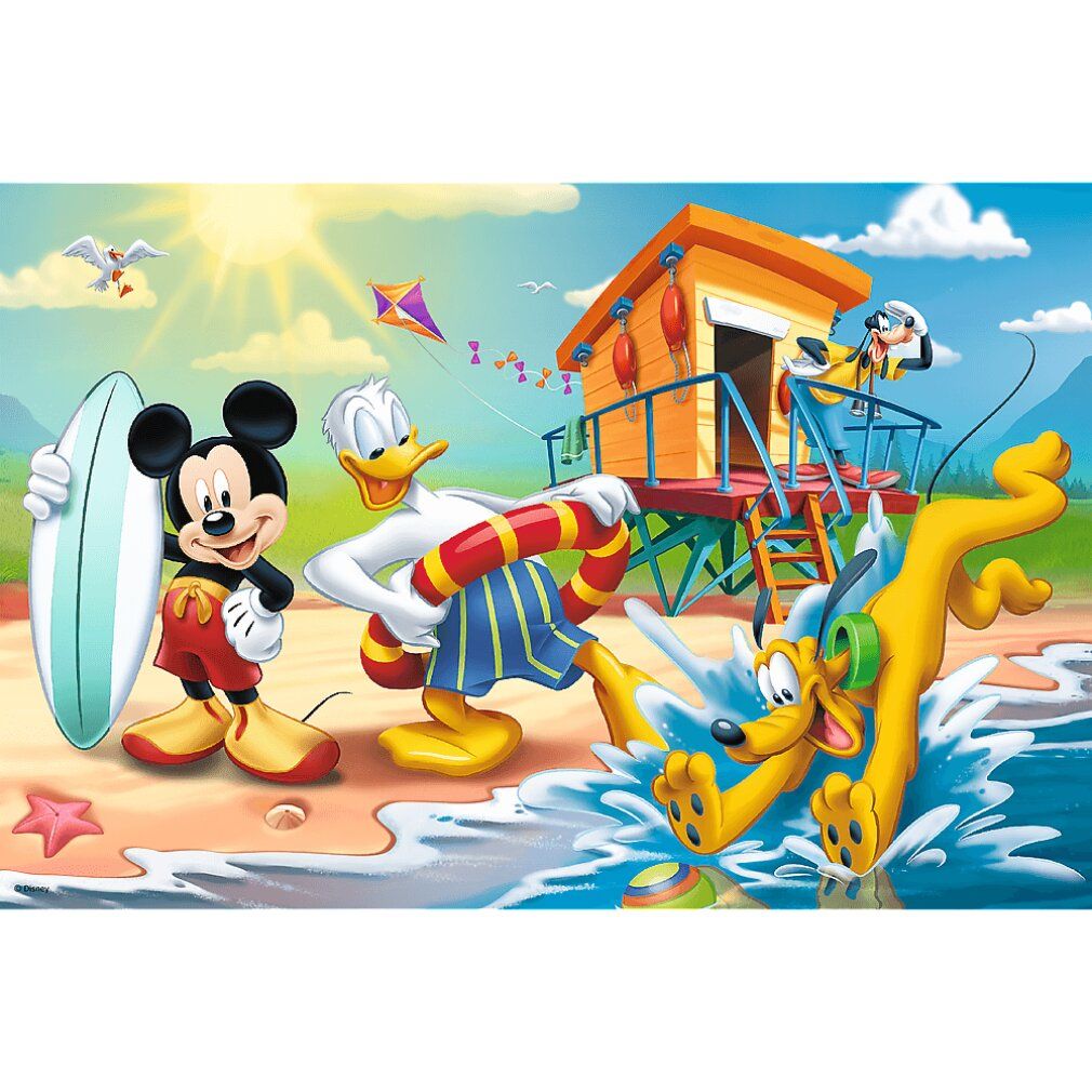 Mickey con tavola da surf, Paperino con salvagente e Pluto sguazzano sulla spiaggia davanti a una torretta di salvataggio.