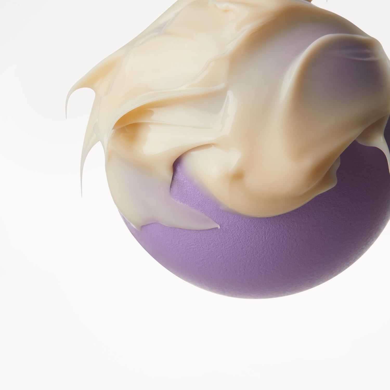 Texture cremosa di Belif Youth Creator Age Knockdown V Cream su una sfera viola.