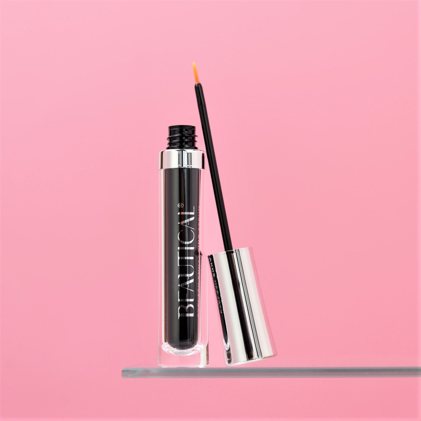 Siero per ciglia Beautical. Flacone nero, tappo argentato, applicatore. Su sfondo rosa.