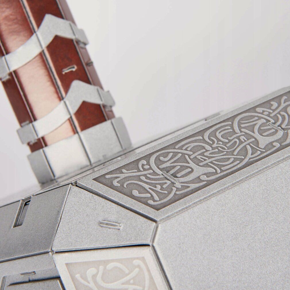 Primo piano dei dettagli della testa del martello. Argento con incisioni. Forme e motivi geometrici.