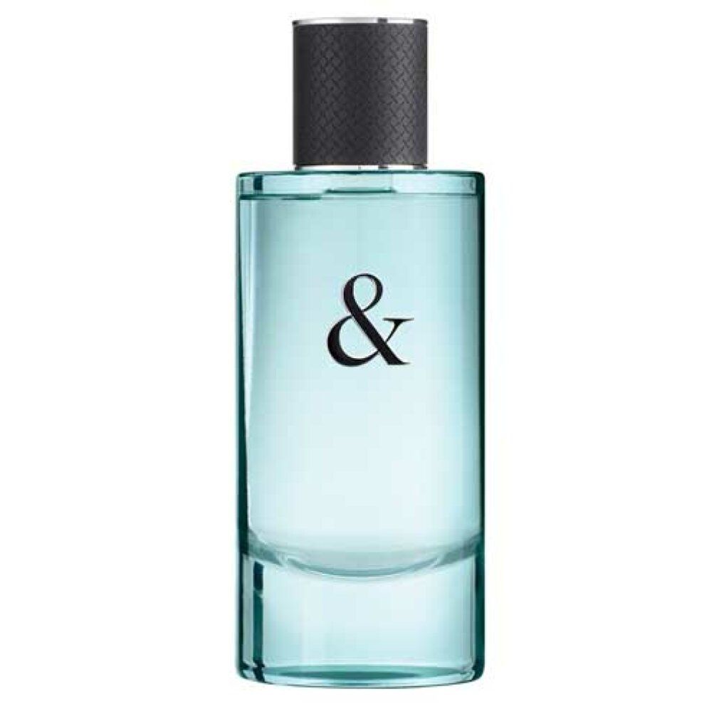 Flacone rettangolare con liquido azzurro e tappo nero. Scritta: &.