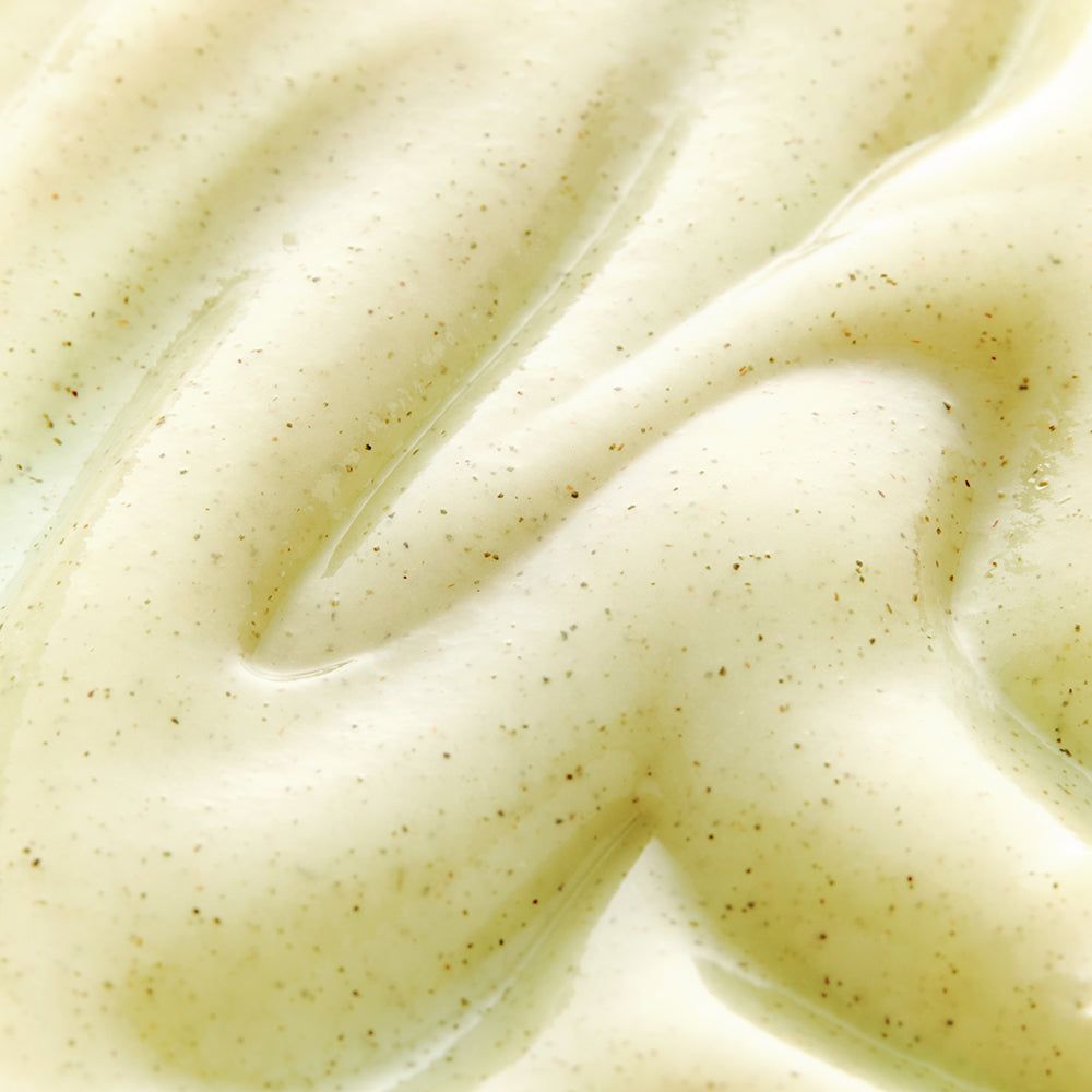 Primo piano di gel color crema. Piccole particelle scure. Superficie ondulata.