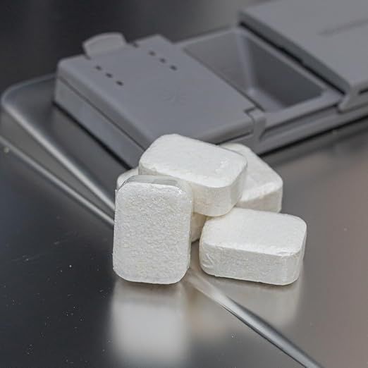 Diversi tabs bianchi in lavastoviglie. Tabs confezionati in pellicola.