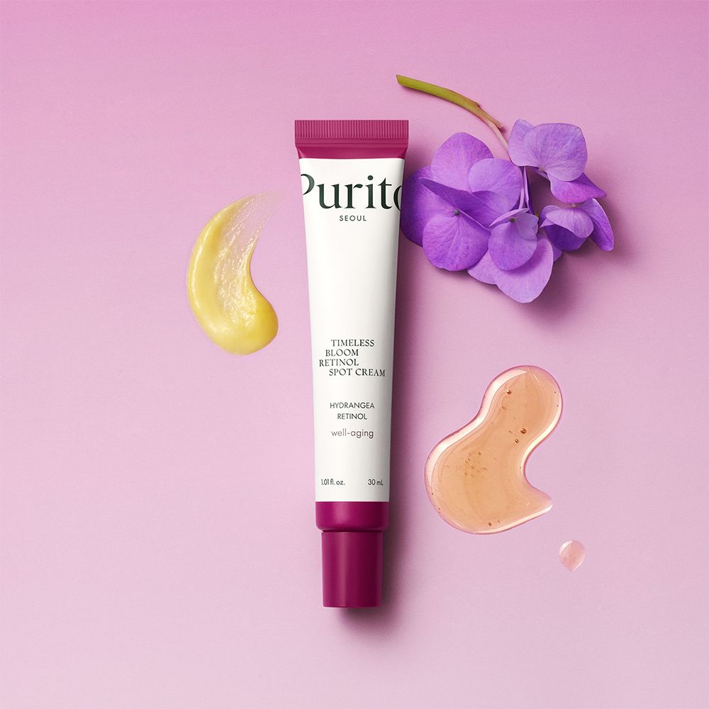 Tubo di crema PURITO Timeless Bloom Retinol Spot Cream con campioni e fiore.
