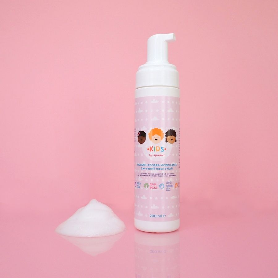 Flacone bianco con etichetta rosa. Scritta: KIDS by Afroricci. Nome del prodotto e loghi. Chiusura a pompa. Schiuma.