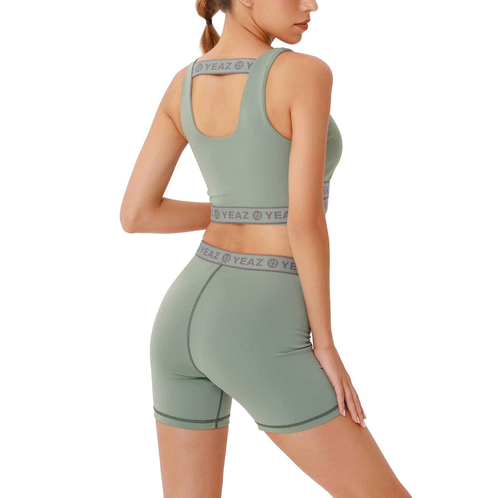 Reggiseno sportivo verde e pantaloncini da ciclista con logo grigio.