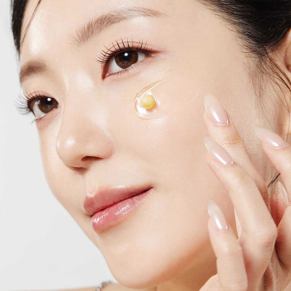 Primo piano di una donna che applica la Medicube Deep Vita C Capsule Cream.
