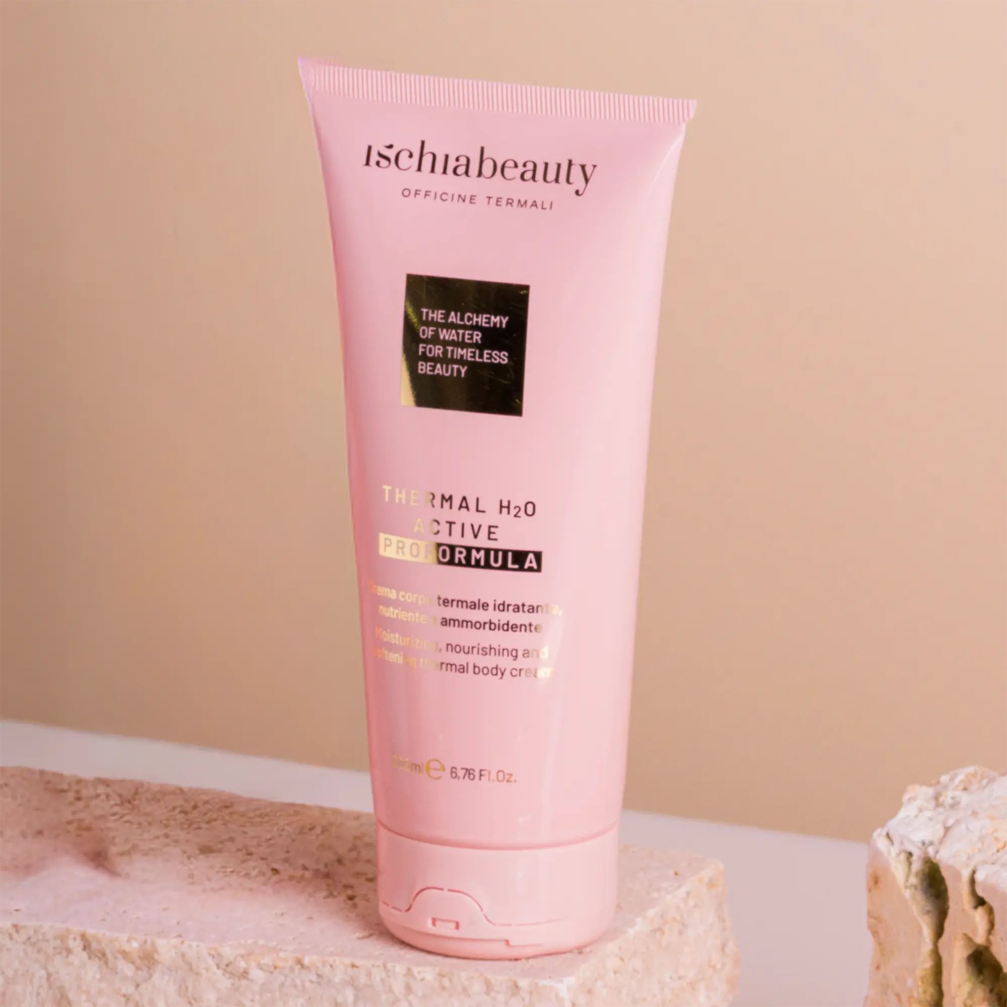 Tubo rosa con testo del prodotto. Scritta: ischiabeauty, Thermal H2O Active Pro Formula. Posizionato su pietra.