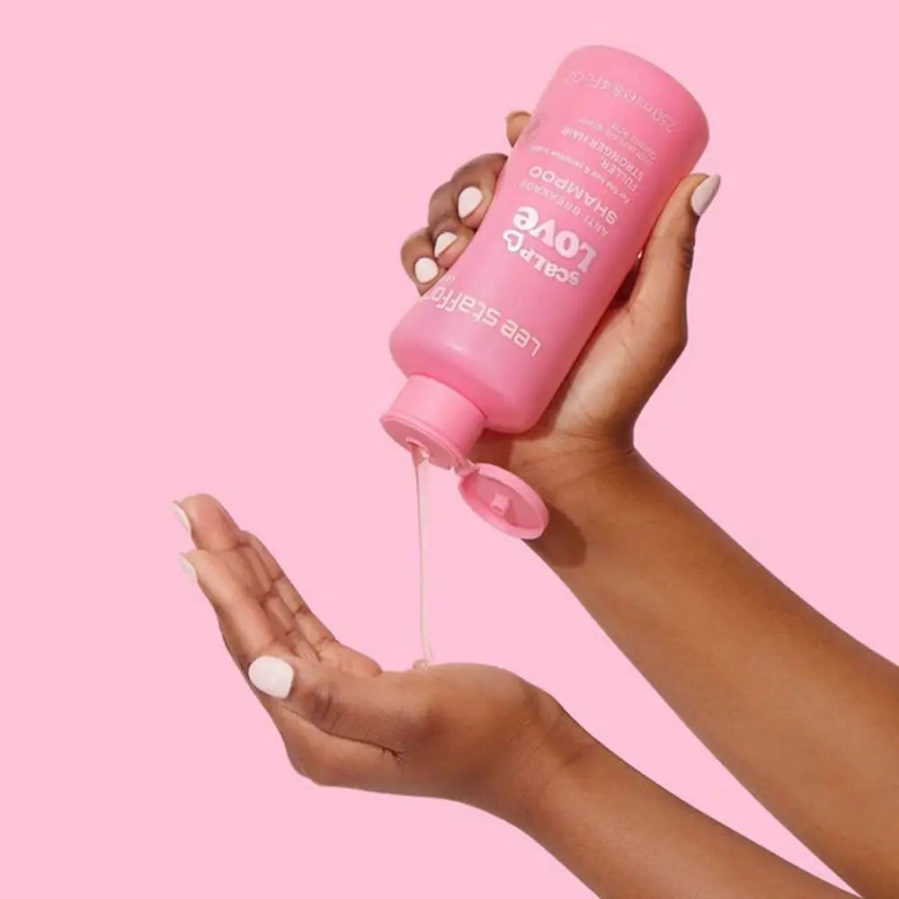 Flacone di shampoo rosa che versa liquido in una mano. Scritta: Scalp Love Anti-Breakage Shampoo.