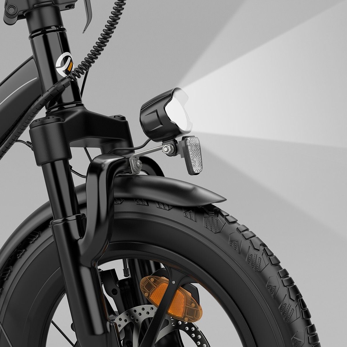 Primo piano del faro di una bici elettrica nera. Raggio di luce visibile.