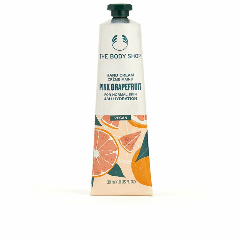 Tubo di crema mani. Bianco, tappo verde. Scritta: Pink Grapefruit, Vegan. Illustrazioni di pompelmo. Marchio: The Body Shop.