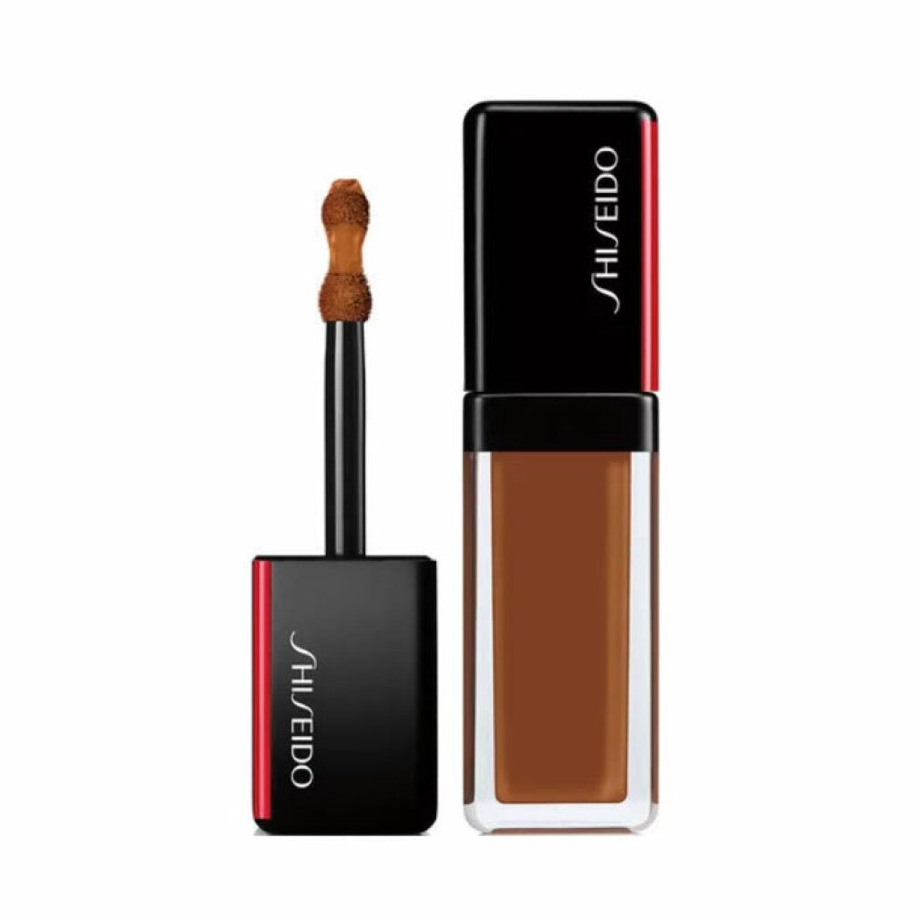 Correttore Shiseido Synchro Skin. Liquido marrone scuro in flacone rettangolare. Tappo nero con accento rosso. Applicatore visibile.