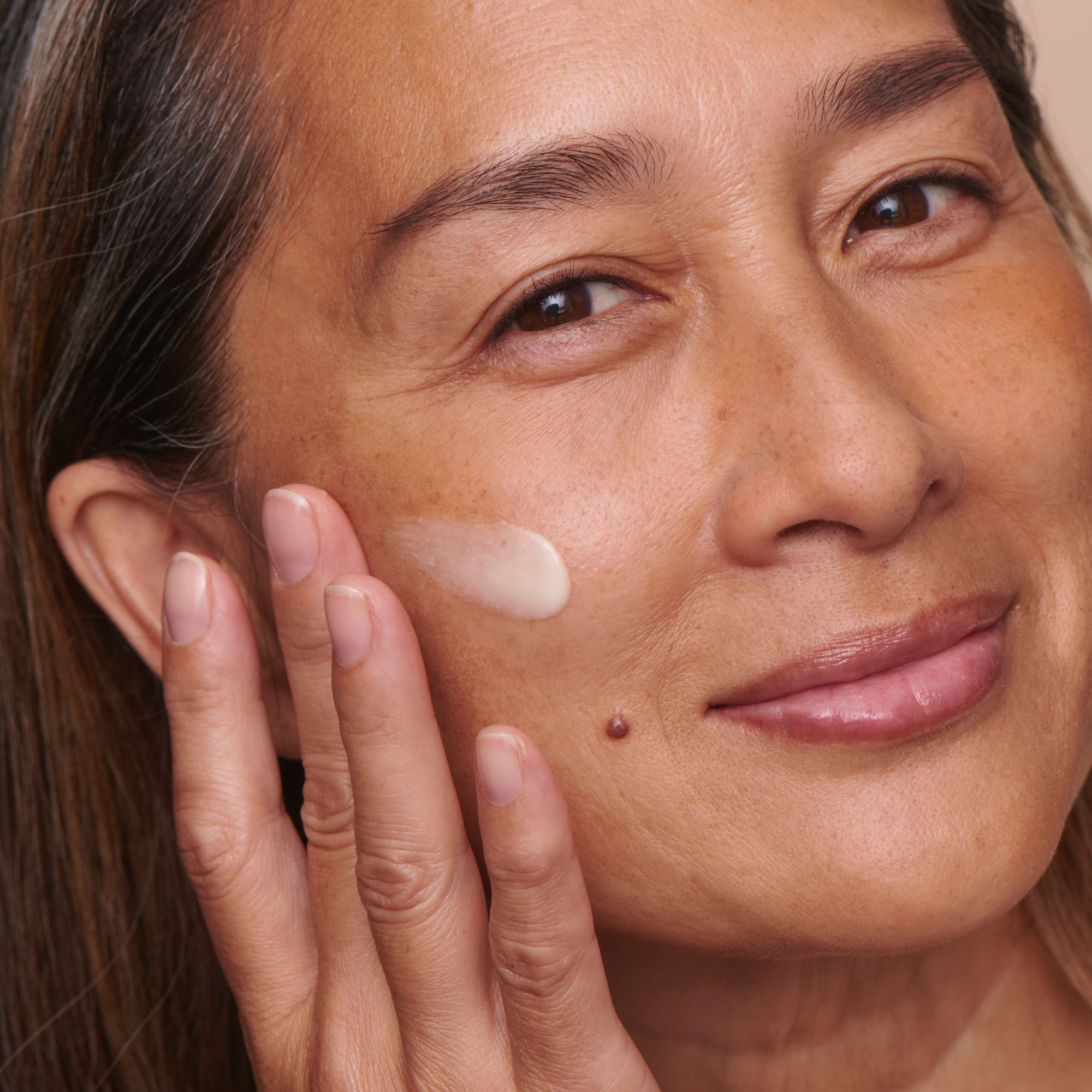 Donna applica siero. Crema sulla pelle. Primo piano del viso.