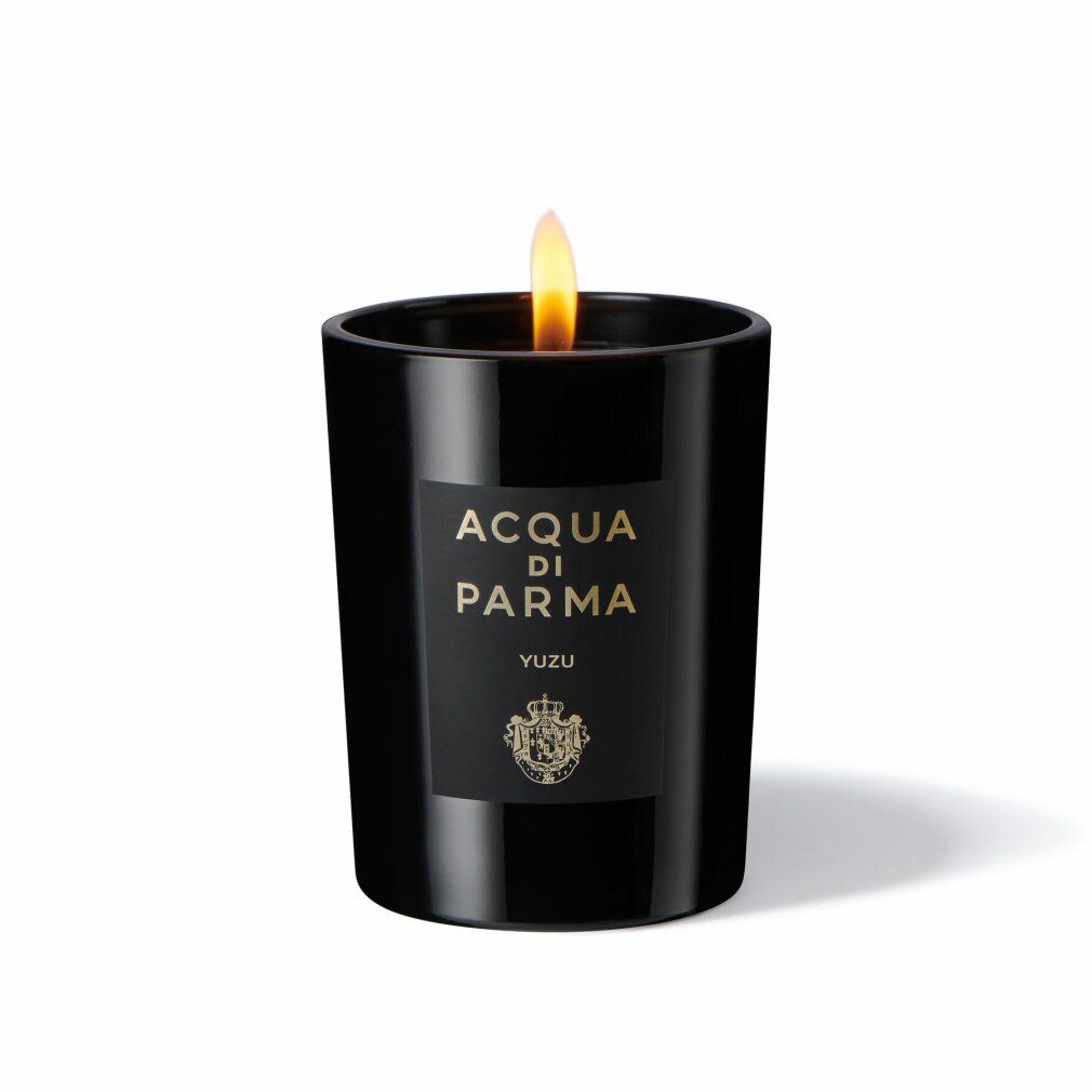 Candela nera con fiamma ed etichetta. Scritta: Acqua Di Parma, Yuzu. Stemma dorato. Forma cilindrica.