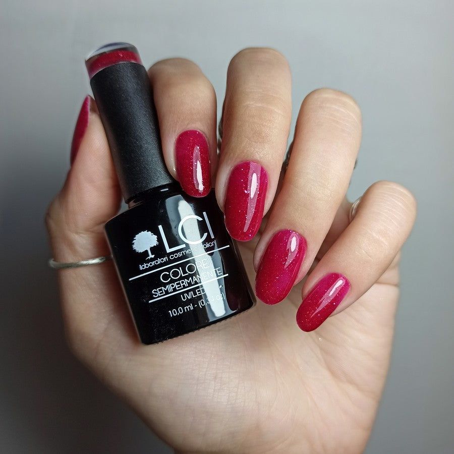 Mano con unghie smaltate e flacone di smalto. Scritta: LCI, Colore Semipermanente, UV/LED 10,0 ml.