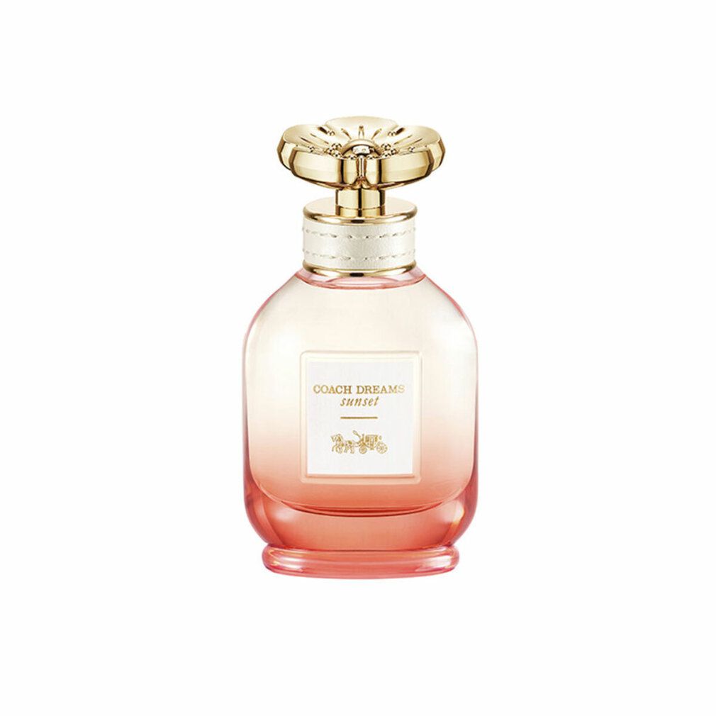 Flacone di profumo con tappo dorato e sfumatura rosa. L'etichetta riporta "COACH DREAMS sunset".