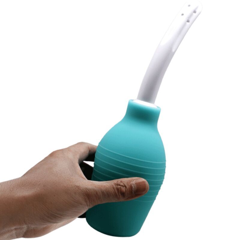 Mano che tiene una doccia anale turchese in gomma con applicatore bianco, isolata su sfondo bianco.