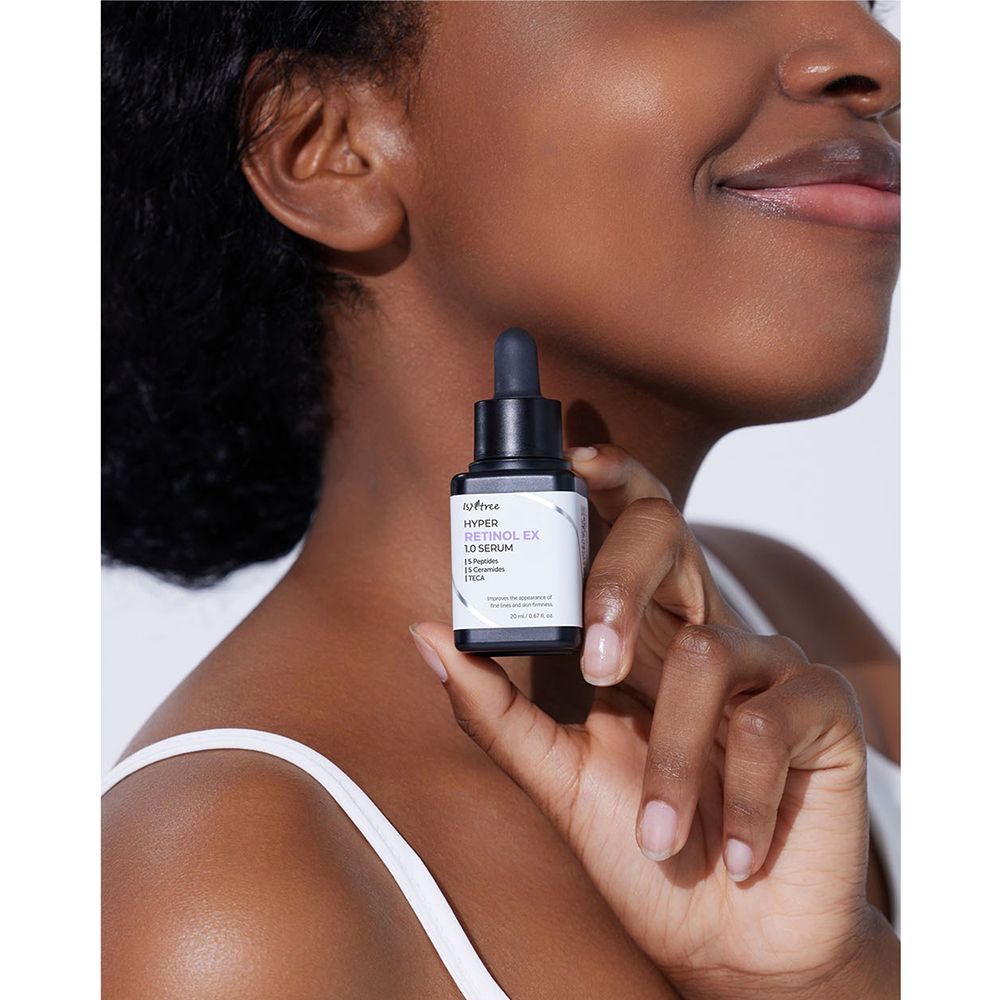 Persona che tiene in mano un flacone nero con etichetta bianca. Scritta: ISNTREE Hyper Retinol EX 1.0 Serum.