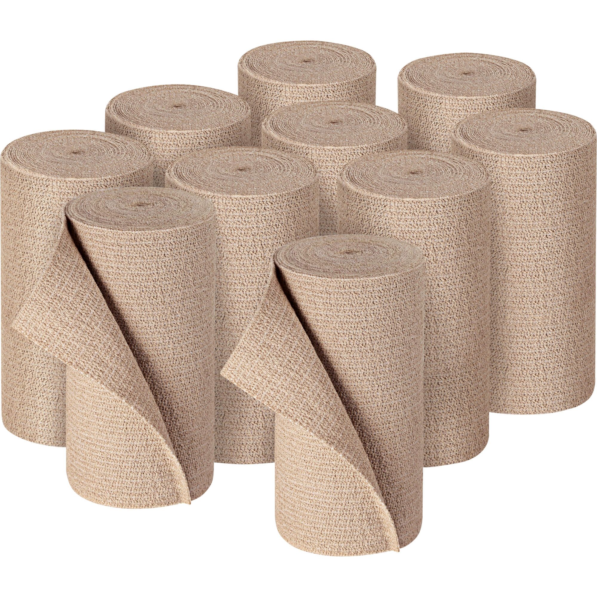 Divers rotoli di bende beige. Alcuni parzialmente srotolati. Tessuto a trama visibile.