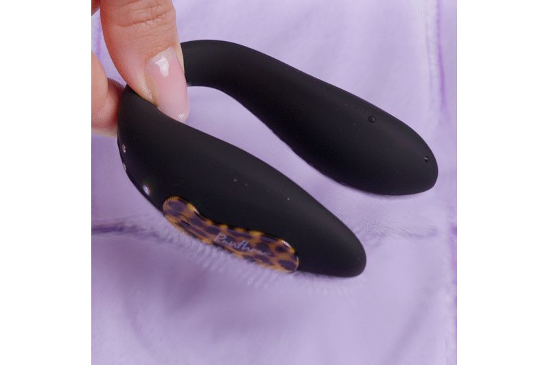 Prodotto nero a forma di U. Parzialmente tenuto in mano. Con elemento marrone a fantasia.