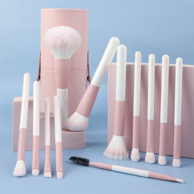 Set di pennelli per trucco con contenitore rosa. Pennelli con manici rosa e bianchi. Varie forme e dimensioni. Include anche un pettine per ciglia.
