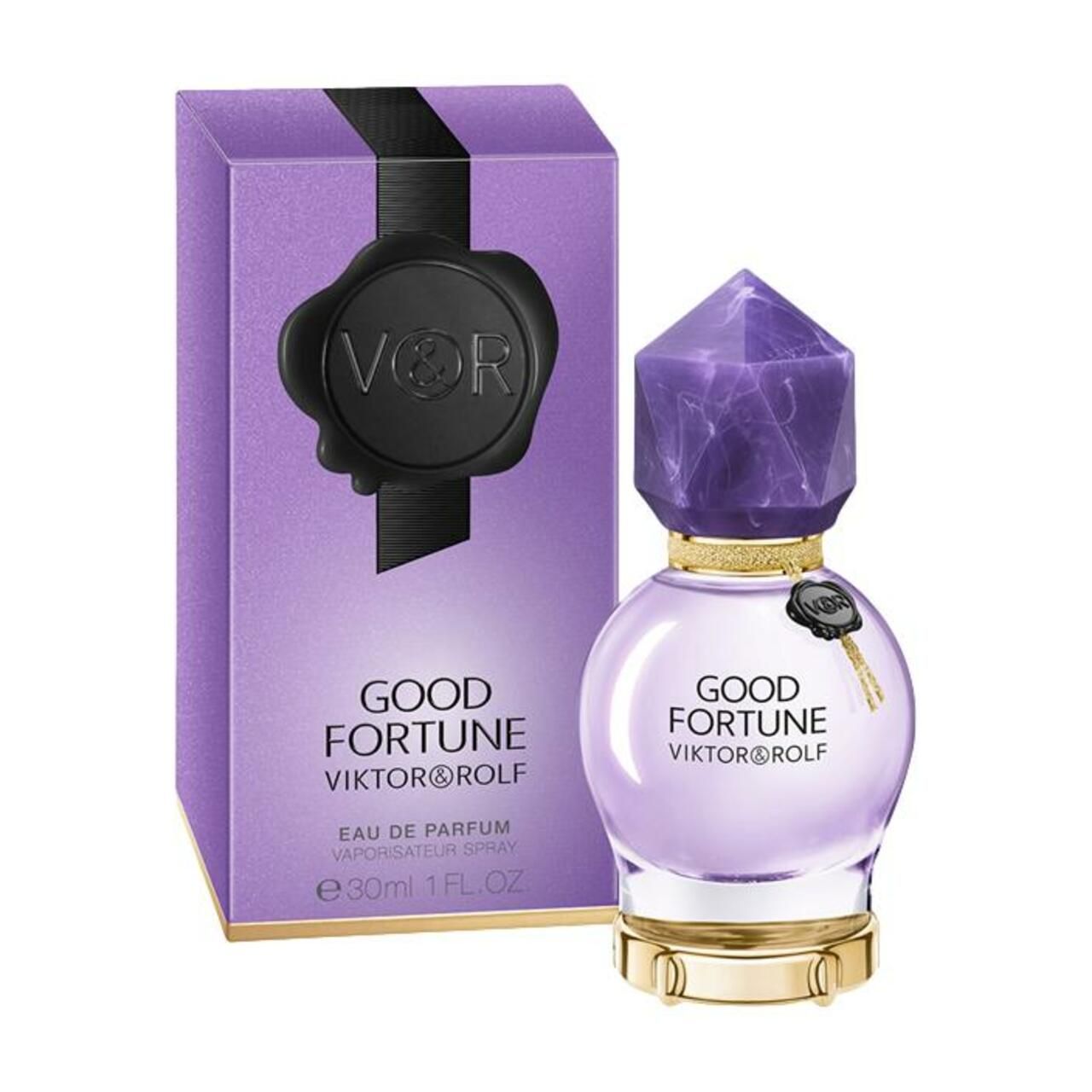 Flacone e confezione viola. Flacone rotondo con tappo di cristallo. Confezione con sigillo nero e scritta.