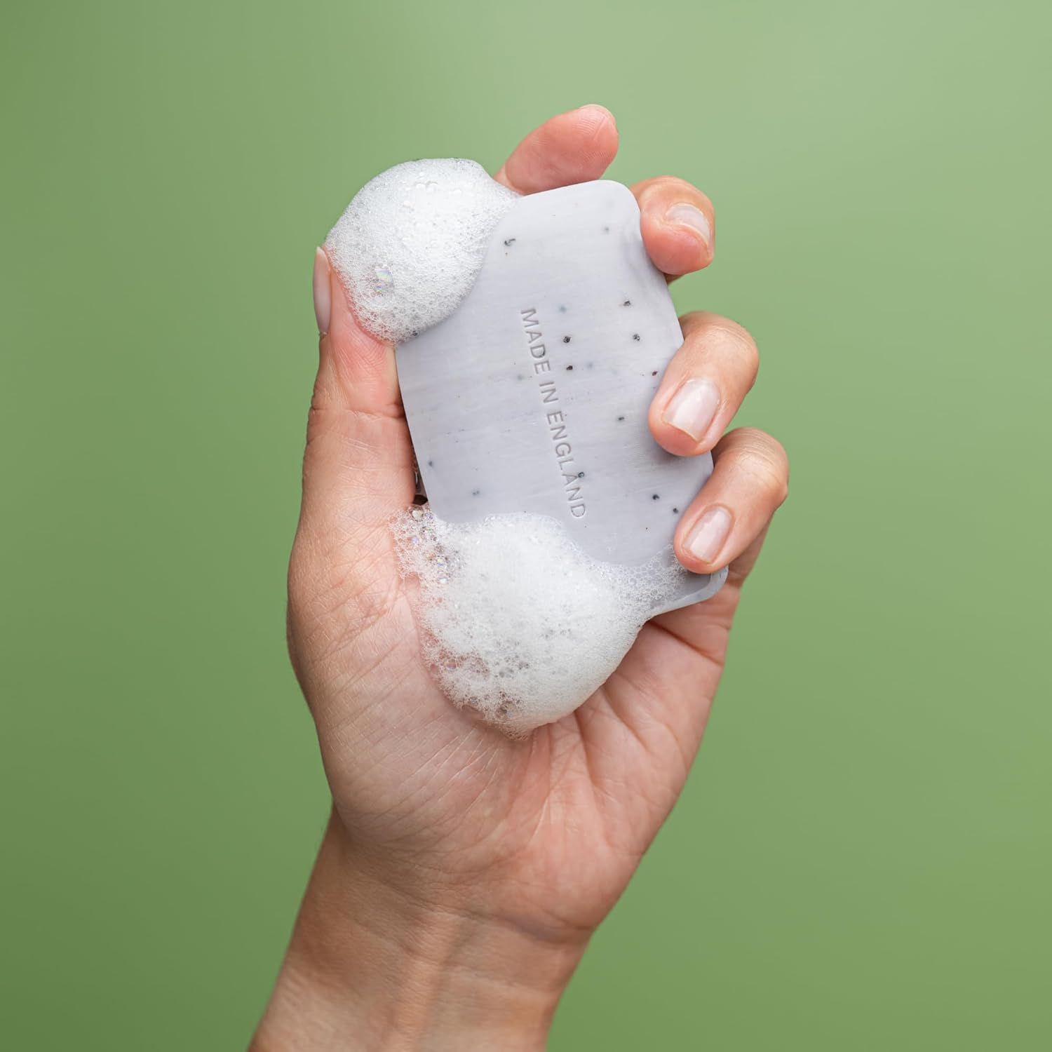 Mano che tiene sapone con schiuma. Scritta: MADE IN ENGLAND.